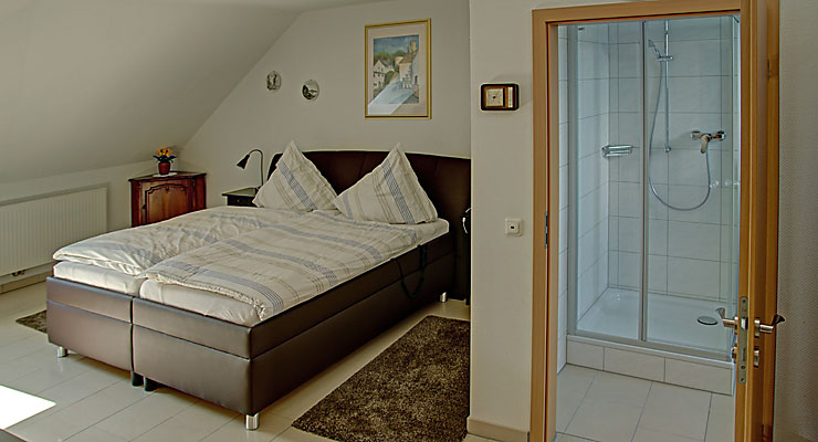 Schlafzimmer mit angrenzendem Bad im Gästehaus Kloep in Hillesheim Schlafzimmer mit Doppelbett im Gästehaus Kloep in Hillesheim